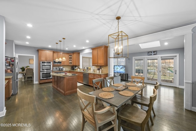 dining room featuring dark hardwood / wood-style floors, a notable chandelier, and a skylight