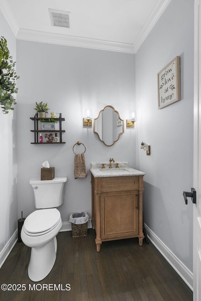 bathroom with vanity, hardwood / wood-style flooring, crown molding, and toilet