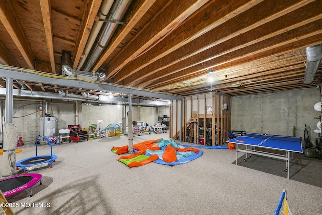 basement featuring gas water heater and carpet flooring