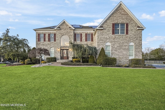 view of front of house featuring a front yard and solar panels