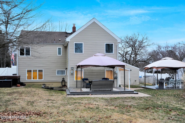 rear view of house with a wooden deck, a gazebo, outdoor lounge area, and a yard