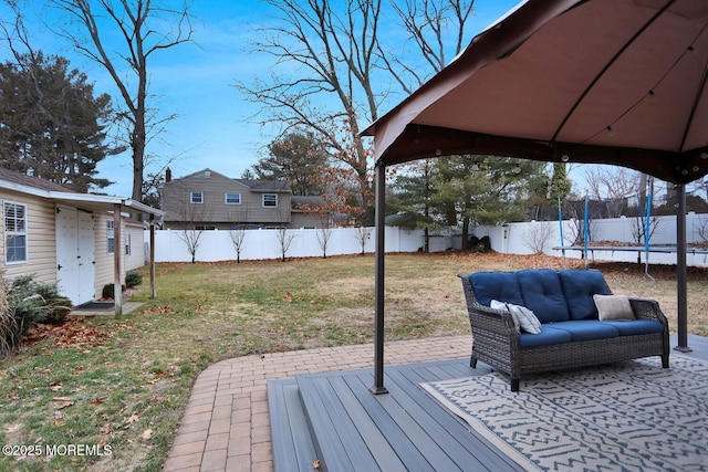 wooden terrace featuring a patio, a yard, and a trampoline