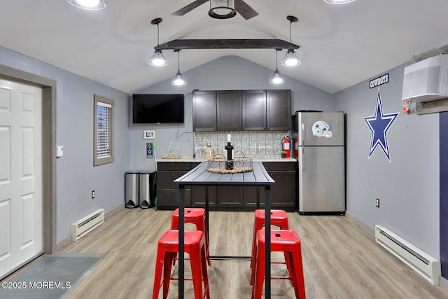 kitchen featuring pendant lighting, stainless steel fridge, light hardwood / wood-style flooring, and a baseboard heating unit