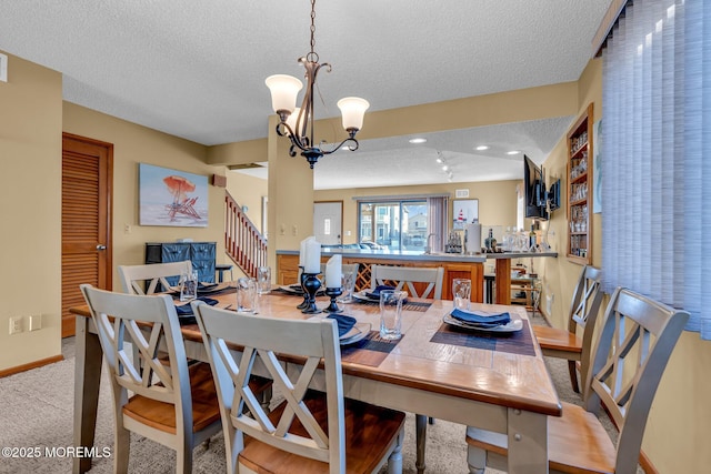 dining space featuring a textured ceiling, light carpet, and an inviting chandelier