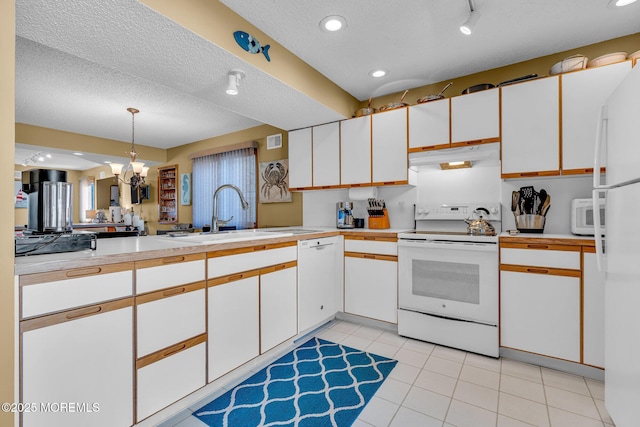 kitchen featuring white cabinets, decorative light fixtures, white appliances, and sink