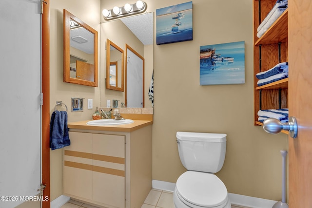 bathroom with vanity, toilet, a textured ceiling, and tile patterned flooring