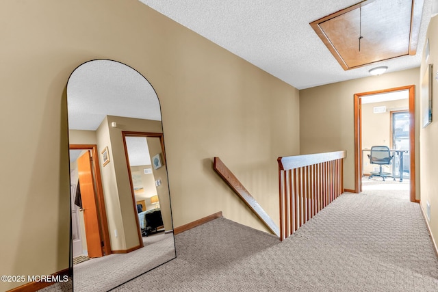 stairs with a textured ceiling and carpet floors