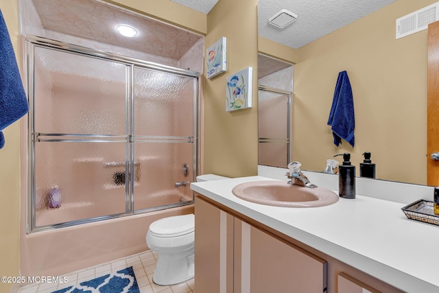 full bathroom with a textured ceiling, enclosed tub / shower combo, tile patterned flooring, vanity, and toilet