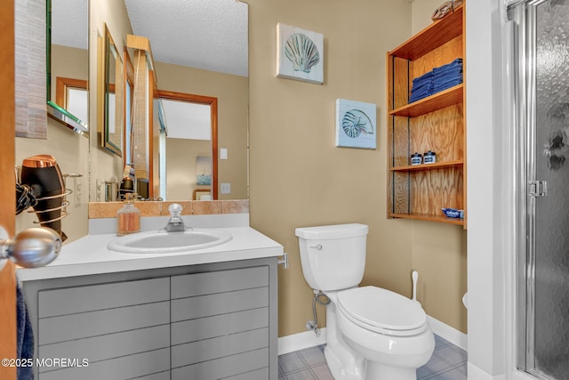 bathroom featuring vanity, toilet, a textured ceiling, and a shower with shower door