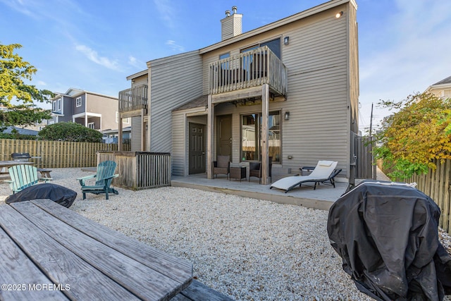 back of property featuring a balcony and a patio area