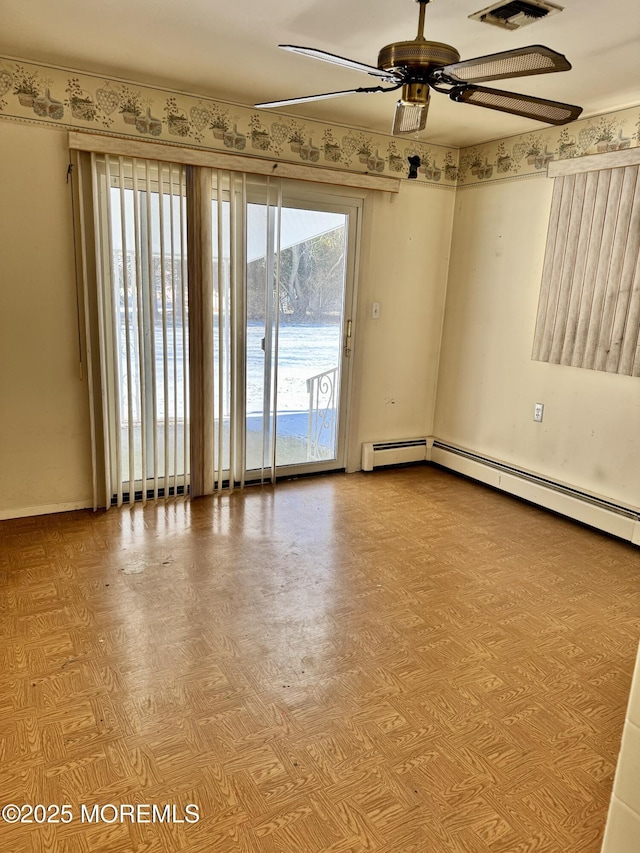 empty room featuring ceiling fan, light parquet floors, and a water view