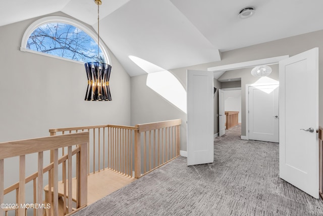 hallway featuring carpet floors and vaulted ceiling