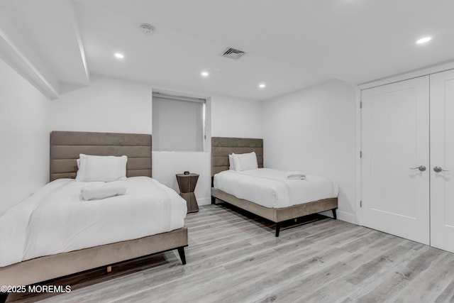 bedroom with light hardwood / wood-style floors and a closet