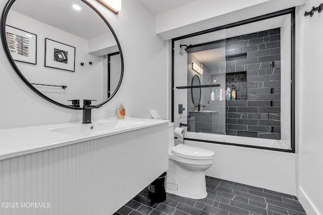 full bathroom featuring bath / shower combo with glass door, toilet, vanity, and tile patterned flooring