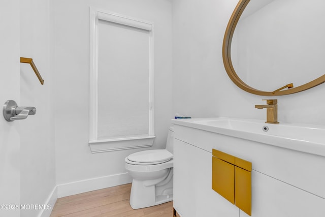 bathroom featuring wood-type flooring, toilet, and vanity