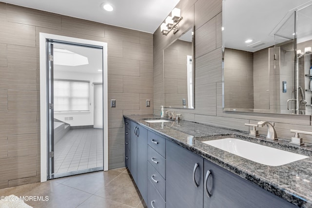 bathroom with tile patterned flooring, vanity, and tile walls