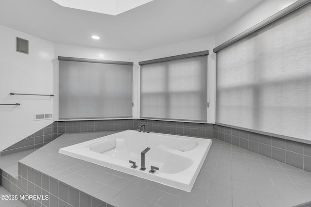 bathroom featuring tile patterned flooring and tiled tub