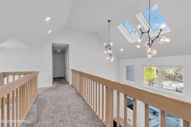 hallway featuring light colored carpet and vaulted ceiling with skylight