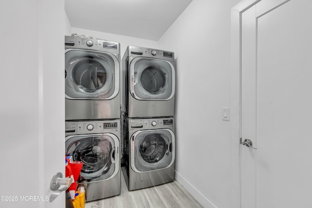 washroom featuring stacked washer / drying machine and light hardwood / wood-style flooring