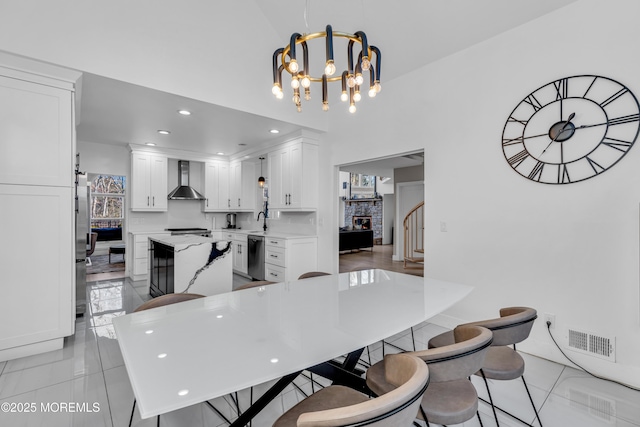 dining space featuring sink, a notable chandelier, and light tile patterned flooring