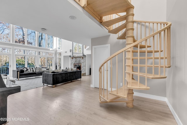 stairway with a high ceiling, hardwood / wood-style floors, and plenty of natural light