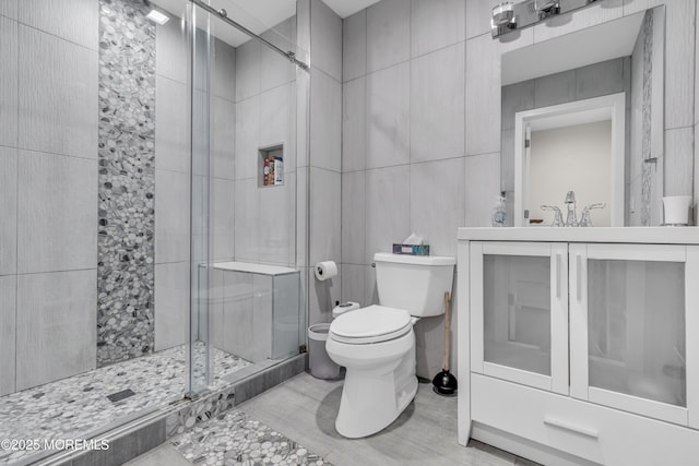 bathroom with vanity, toilet, and a shower with shower door