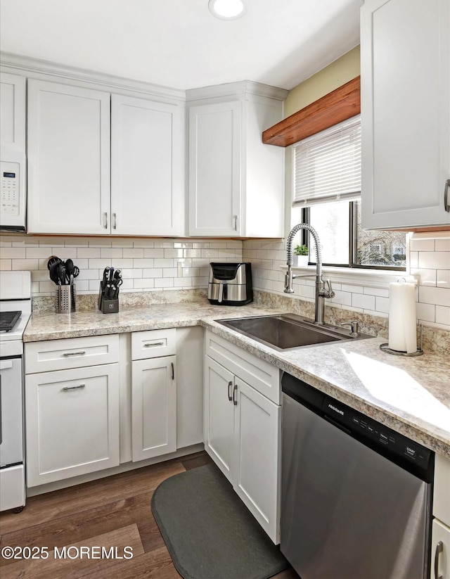 kitchen featuring tasteful backsplash, white cabinetry, sink, dark wood-type flooring, and white appliances