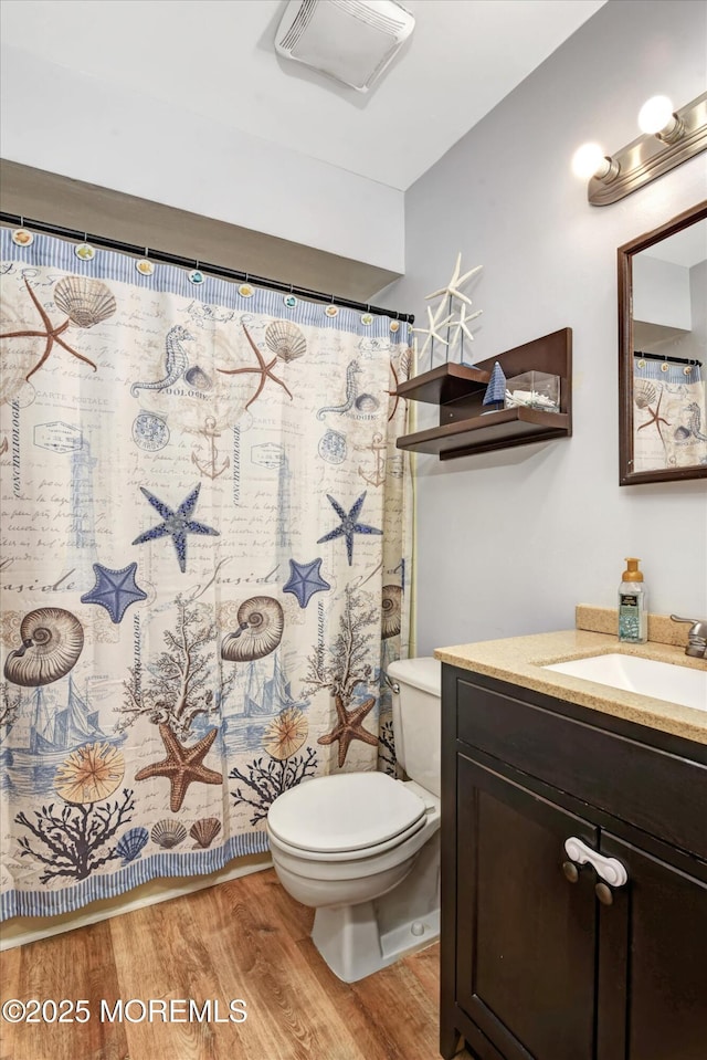 bathroom featuring vanity, hardwood / wood-style flooring, a shower with curtain, and toilet