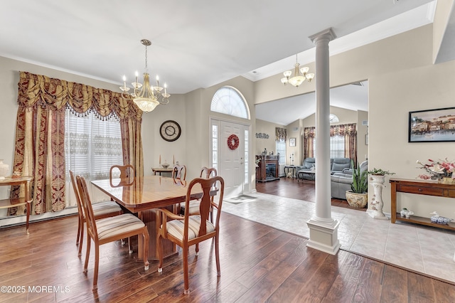 dining area featuring wood-type flooring, ornate columns, and a healthy amount of sunlight