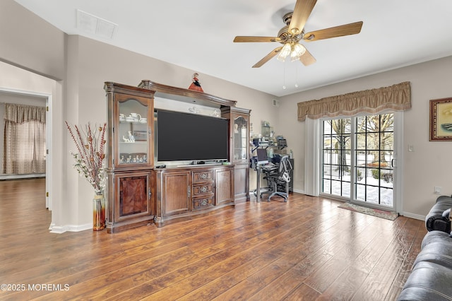 living room with ceiling fan and dark wood-type flooring