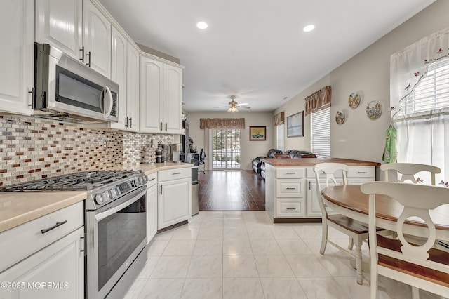 kitchen with white cabinets, ceiling fan, and stainless steel appliances