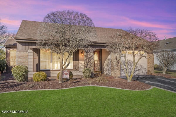 view of front of home with a yard and a garage