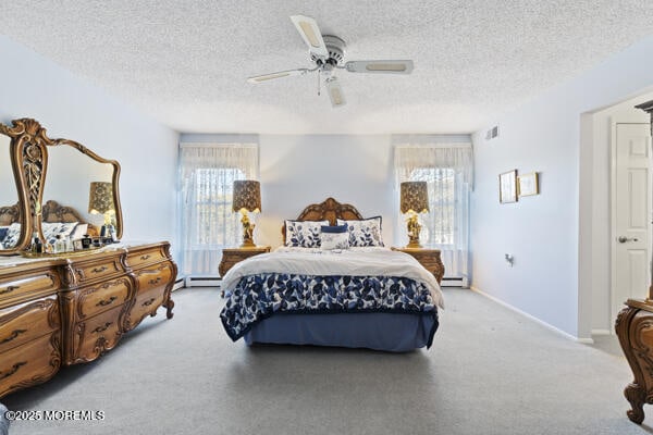 carpeted bedroom with ceiling fan, a textured ceiling, and baseboard heating