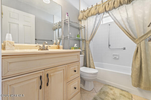 full bathroom with tile patterned floors, toilet, shower / bath combo with shower curtain, and vanity