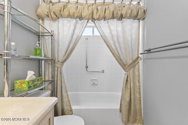 full bathroom with vanity, shower / bath combination with curtain, and toilet