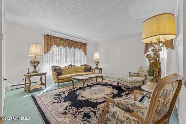 carpeted living room with a baseboard heating unit and a textured ceiling