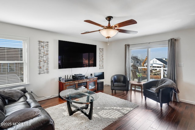 living room featuring ceiling fan and dark hardwood / wood-style flooring