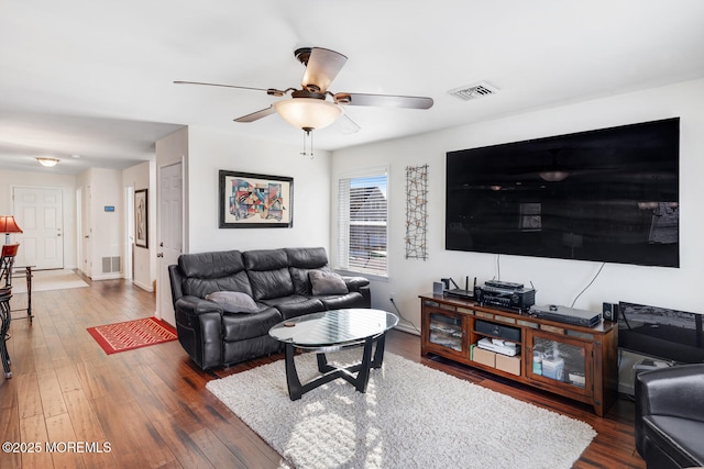 living room featuring ceiling fan and dark wood-type flooring