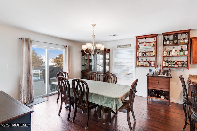 dining area with an inviting chandelier and dark hardwood / wood-style floors