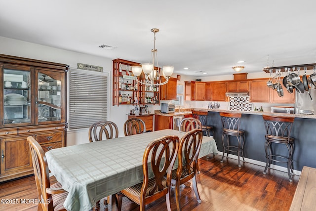 dining room with a notable chandelier and dark hardwood / wood-style flooring