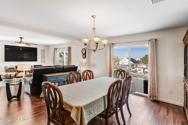 dining space with dark wood-type flooring, ceiling fan with notable chandelier, and a wealth of natural light