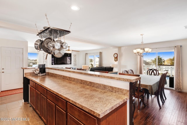 kitchen with hardwood / wood-style flooring, a center island, a notable chandelier, and pendant lighting