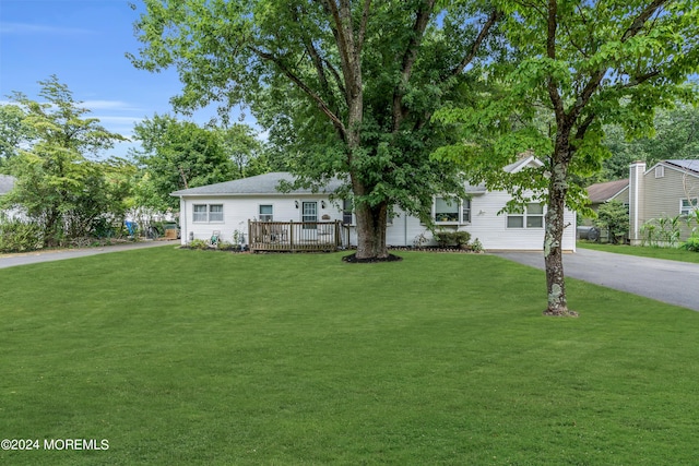 ranch-style house with a front yard and a deck