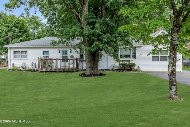 rear view of property with a lawn and a deck