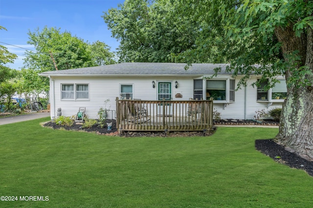 rear view of house featuring a deck and a lawn