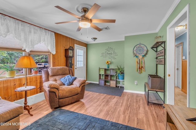 living area featuring ceiling fan, crown molding, and wood-type flooring