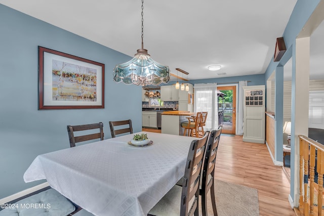 dining area with sink and light hardwood / wood-style floors