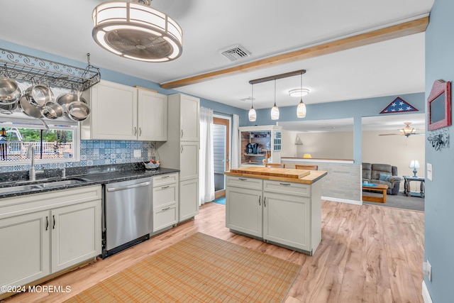 kitchen with stainless steel dishwasher, sink, light wood-type flooring, a center island, and decorative backsplash