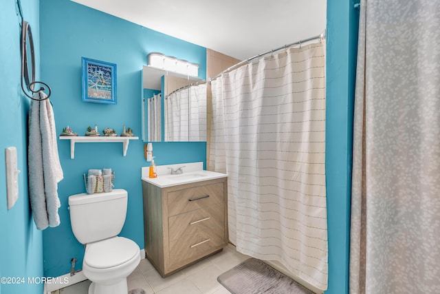 bathroom with toilet, tile patterned flooring, walk in shower, and vanity