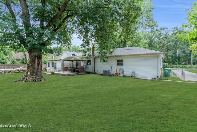 back of house featuring a deck, a gazebo, a lawn, and central AC